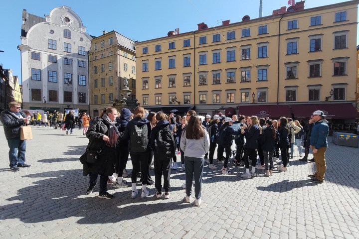 a group of people having a guided tour in front of a building